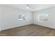Bright bedroom featuring wood-look floors, a ceiling fan, and two windows offering ample natural light at 16215 N 35Th Pl, Phoenix, AZ 85032