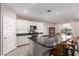 Spacious kitchen with white cabinetry, black countertops, stainless appliances, and an island with bar seating at 17017 N Palo Azul Rd, Maricopa, AZ 85138
