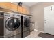 Functional laundry room featuring modern appliances, storage cabinets, and convenient access to the exterior at 17017 N Palo Azul Rd, Maricopa, AZ 85138