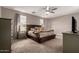 Cozy main bedroom with a ceiling fan, neutral tones, and two large windows at 17017 N Palo Azul Rd, Maricopa, AZ 85138