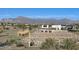 Community entrance with a landscaped roundabout, welcome signage, and mountain views in the background at 17260 W Daley Ln, Surprise, AZ 85387