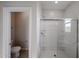 Bathroom featuring a modern glass shower, white walls and tile, and an adjacent toilet at 17266 W Daley Ln, Surprise, AZ 85387