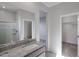 Neutral bathroom featuring a granite countertop sink, glass shower, and doorways to other rooms at 17266 W Daley Ln, Surprise, AZ 85387
