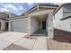 Charming home featuring a concrete driveway, brick accents, and covered front entry at 17266 W Daley Ln, Surprise, AZ 85387