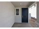 Inviting front entrance with a navy blue door and covered porch at 17266 W Daley Ln, Surprise, AZ 85387