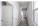 Bright hallway with tile flooring, white walls, and multiple doors, leading to other rooms at 17266 W Daley Ln, Surprise, AZ 85387