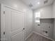 Functional laundry room with tile floors, utility connections, and a window at 17266 W Daley Ln, Surprise, AZ 85387