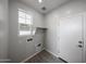 Functional laundry room with tile floors, utility connections, and a window at 17266 W Daley Ln, Surprise, AZ 85387