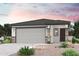 Charming single-story home with a gray roof, three-car garage, stone accents, and desert landscaping at 17289 W Daley Ln, Surprise, AZ 85387