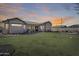 Expansive backyard with lush lawn, patio, fire pit, and mature trees, perfect for outdoor living at 1785 S 222Nd Ln, Buckeye, AZ 85326