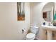 Well-lit half bathroom featuring a modern pedestal sink, updated fixtures, and stylish decor at 1785 S 222Nd Ln, Buckeye, AZ 85326