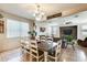 Bright dining room with a dark wooden table, white chairs, and a chandelier at 1785 S 222Nd Ln, Buckeye, AZ 85326