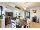 Open dining room with a dark wooden table, white chairs, and decorative lighting at 1785 S 222Nd Ln, Buckeye, AZ 85326
