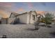 A charming house showing low-maintenance landscaping, neutral stucco facade, and a glimpse of the three-car garage at 1785 S 222Nd Ln, Buckeye, AZ 85326