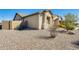 Well-maintained home exterior showcasing a desert landscape and attached garage at 1785 S 222Nd Ln, Buckeye, AZ 85326