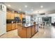 The modern kitchen is equipped with an island, stainless appliances, granite countertops, and tile flooring at 1785 S 222Nd Ln, Buckeye, AZ 85326