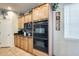 A kitchen features wooden cabinets, a built-in oven and microwave, tile floors, and stainless steel appliances at 1785 S 222Nd Ln, Buckeye, AZ 85326