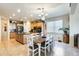 Open kitchen and dining area features wood cabinetry, stainless appliances, and a large center island at 1785 S 222Nd Ln, Buckeye, AZ 85326