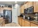 The kitchen features stainless steel appliances, wooden cabinets, and a tiled backsplash with modern design at 1785 S 222Nd Ln, Buckeye, AZ 85326