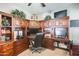 Spacious home office with a large custom built-in desk, storage cabinets, and ceiling fan at 1785 S 222Nd Ln, Buckeye, AZ 85326