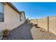 Narrow side yard with gravel landscaping and tall privacy wall at 1785 S 222Nd Ln, Buckeye, AZ 85326