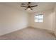 Bright bedroom with a ceiling fan, neutral carpet, and a window offering serene views at 1816 W Villa Maria Dr, Phoenix, AZ 85023