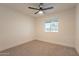 Well-lit bedroom featuring plush carpeting, a ceiling fan, and a window with pleasant neighborhood views at 1816 W Villa Maria Dr, Phoenix, AZ 85023