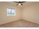 Bright bedroom offers a ceiling fan, neutral carpeting, and a window for natural light and ventilation at 1816 W Villa Maria Dr, Phoenix, AZ 85023