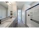 Modern bathroom with double sinks, granite counters and glass shower at 18243 W Daley Ln, Surprise, AZ 85387