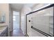 Bathroom with gray countertops, tiled flooring, and glass-door shower with modern shower head at 18243 W Daley Ln, Surprise, AZ 85387