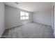 Carpeted bedroom with a large window provides natural light at 18243 W Daley Ln, Surprise, AZ 85387