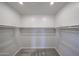 A well-lit walk-in closet featuring ample storage space with rods for hanging clothes at 18243 W Daley Ln, Surprise, AZ 85387
