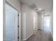 Bright hallway featuring modern tile flooring and white paneled doors at 18243 W Daley Ln, Surprise, AZ 85387