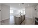 Open-concept kitchen with island featuring granite countertops, stainless sink, and modern faucet at 18243 W Daley Ln, Surprise, AZ 85387