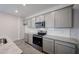 Bright modern kitchen featuring stainless appliances, granite countertops, and gray cabinets at 18243 W Daley Ln, Surprise, AZ 85387