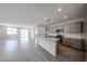 Open-concept living space with a kitchen island, recessed lighting, and large windows at 18243 W Daley Ln, Surprise, AZ 85387