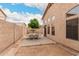 Backyard area featuring a stone wall, dining table, and arid landscaping, ideal for outdoor gatherings at 2025 N 106Th Dr, Avondale, AZ 85392