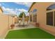 Private backyard with artificial turf, potted plants, and outdoor dining set at 2025 N 106Th Dr, Avondale, AZ 85392