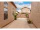 A concrete patio between two homes with desert landscaping, concrete block walls, and blue skies at 2025 N 106Th Dr, Avondale, AZ 85392