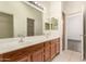 Large bathroom vanity with double sinks, wood cabinets, and modern lighting at 2025 N 106Th Dr, Avondale, AZ 85392