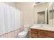 Neutral bathroom featuring a single sink vanity, toilet, framed mirror, and a shower-tub combo at 2025 N 106Th Dr, Avondale, AZ 85392