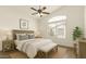 Cozy bedroom featuring a large window, ceiling fan, and stylish furnishings at 2025 N 106Th Dr, Avondale, AZ 85392