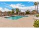Community pool with light blue water, several lounge chairs, and desert landscaping at 2025 N 106Th Dr, Avondale, AZ 85392