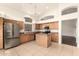 Open concept kitchen with tile flooring, central island, stainless steel appliances and bright natural light at 2025 N 106Th Dr, Avondale, AZ 85392