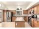Well-lit kitchen features stainless steel appliances, wooden cabinets and a functional center island at 2025 N 106Th Dr, Avondale, AZ 85392