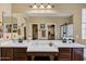 Bathroom with double sinks, brown cabinets, a large mirror, and a view to the shower at 2280 E Aloe Pl, Chandler, AZ 85286