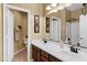 Well-lit bathroom featuring double sinks with dark cabinets and a shower behind the mirror at 2280 E Aloe Pl, Chandler, AZ 85286