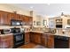 A kitchen features dark wood cabinets, granite countertops, and stainless steel appliances at 2280 E Aloe Pl, Chandler, AZ 85286