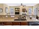 A kitchen island features a black sink, granite countertops, dark wood cabinets, and stainless steel appliances at 2280 E Aloe Pl, Chandler, AZ 85286
