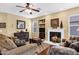 Cozy living room with a fireplace, ceiling fan, and comfortable seating at 2280 E Aloe Pl, Chandler, AZ 85286